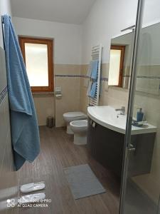 ein Badezimmer mit einem Waschbecken, einem WC und einem Spiegel in der Unterkunft Bed & Breakfast Le cicale e la formica in Casarza Ligure