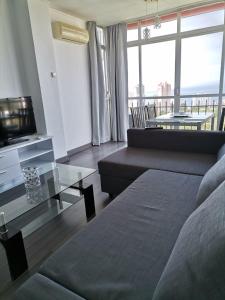a living room with a couch and a glass table at Club Medico Torre VI in Benidorm