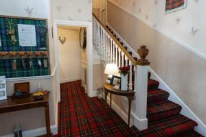 a stairway leading to a living room with a red carpet at Aye Stay in Inverness