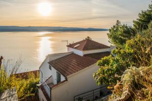 een huis aan de oever van een meer bij zonsondergang bij VILLA LEON*** in Mimice