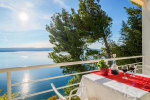 een tafel met wijnglazen op een balkon met uitzicht op het water bij VILLA LEON*** in Mimice