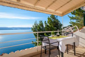 een tafel en stoelen op een balkon met uitzicht op het water bij VILLA LEON*** in Mimice