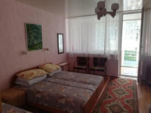 a bedroom with a bed and a large window at Apartmentai Baltoji Ramune in Palanga