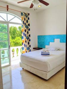 1 dormitorio con cama y ventana grande en 3br PHouse Rooftop terrace with plunge pool and ocean view walk to beach 5th ave and Cozumel Ferry en Playa del Carmen
