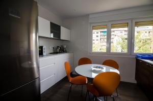 a kitchen with a table and chairs and a kitchen with a refrigerator at Pensión Ibai Ega in Estella