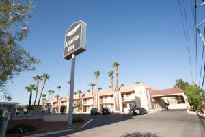 un letrero de la calle frente a un hotel con palmeras en Aviation Inn en Las Vegas