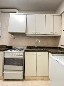 a kitchen with white cabinets and a stainless steel oven at Departamento en Edificio Presidente Plaza España in Mendoza