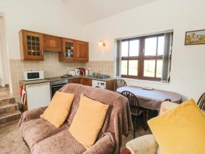 a kitchen with a couch and a table in a room at The Calf House in Boosbeck