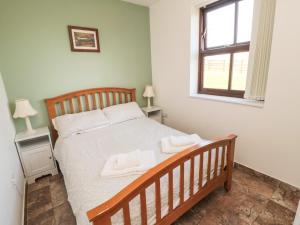 a bedroom with a bed with two towels on it at The Calf House in Boosbeck