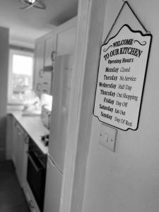 a kitchen with a sign on a wall at Entire Stylish 1 Bedroom Flat with Free Parking in Dundee