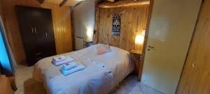 a bedroom with a bed with towels on it at El Cipresal- Cabaña Epuyen in San Martín de los Andes