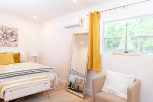 a bedroom with a mirror and a bed and a chair at Beautiful Casita with King Bed and private patio Close to Calle 8, MIA Airport, Coral Gables in Miami
