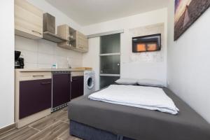 a small bedroom with a bed and a kitchen at Studio Apartment PineTree - Mali Lošinj in Mali Lošinj