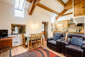 a living room with a couch and a table and a kitchen at Bythyn Ddol Hafod in Capel-Curig