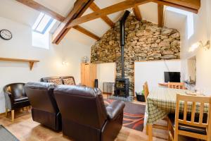 a living room with a table and chairs and a stone wall at Bythyn Ddol Hafod in Capel-Curig