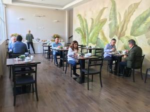 een groep mensen die aan tafel zitten in een restaurant bij Hotel Tito in Arequipa