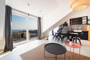 a living room with a table and chairs and a large window at Divine Apartment in Mlini