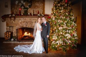 Una novia y un novio parados frente a un árbol de Navidad en Carmel Valley Lodge, en Carmel Valley