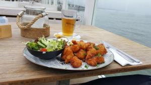 a plate of food with a salad and a glass of beer at Ferienhhaus-Mobilheim freies WLAN in Sirjansland