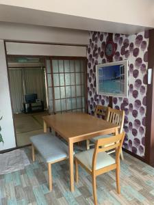 a wooden table and chairs in a room at Kurosaki Guesthouse 403 in Kitakyushu