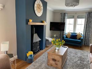 a living room with a fireplace and a clock on the wall at Alnmouth Coastal properties close to Beach with Parking in Alnmouth
