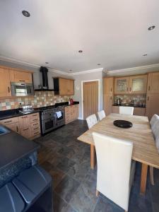 uma cozinha com uma mesa de madeira e cadeiras brancas em Alnmouth Coastal properties close to Beach with Parking em Alnmouth