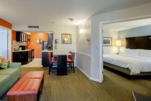 ein Hotelzimmer mit einem Bett und einem Wohnzimmer in der Unterkunft Sonesta ES Suites Orlando - Lake Buena Vista in Orlando