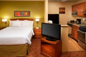 Sonesta Simply Suites Detroit Novi في نوفي: غرفة فندقية بسرير وتلفزيون بشاشة مسطحة