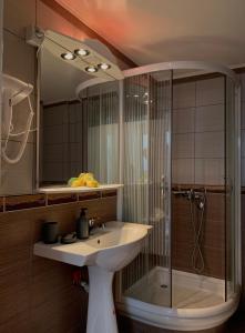 a bathroom with a glass shower and a sink at APARTMANI LAVAZZA in Vlasotince