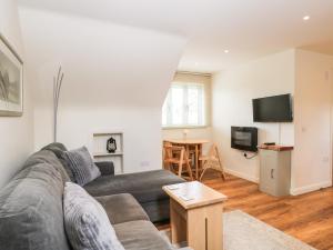 a living room with a couch and a tv at Shephards Retreat in Kingsdon