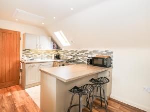 a kitchen with a counter and two stools at Shephards Retreat in Kingsdon