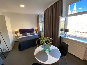 um quarto de hotel com uma mesa e uma cama e uma janela em Apartments DOLAC 1 Zagreb em Zagreb