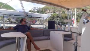 a woman sitting on a couch on a boat at Catamaran Cypraea in Terre-de-Haut