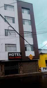 un hotel con un cartel frente a un edificio en Hotel Villa Isabel en Pasto
