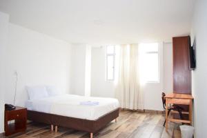 um quarto com uma cama grande e uma janela em Hotel Villa Isabel em Pasto