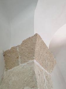 a corner of a stone wall in a room at Masseria Vivi il Salento in Santa Caterina di Nardò
