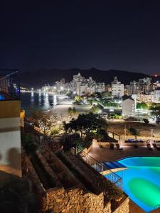 a view of a city and a body of water at night at El Peñon del Rodadero - Apto 1303A in Santa Marta