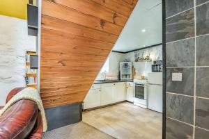une cuisine mansardée avec un mur en bois dans l'établissement Celyn Farm Cottage, à Cwm-y-glo 9 autres photos