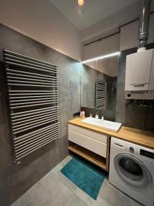een badkamer met wastafel en wasmachine bij Przytulny Apartament w Centrum in Częstochowa