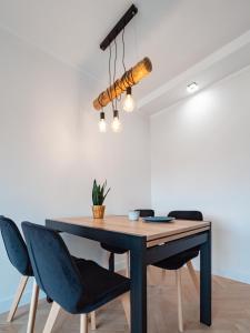 stół jadalny z krzesłami i żyrandolem w obiekcie Apartament Bursztynowy Nowy w mieście Sopot