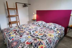 a bedroom with a bed with a colorful blanket at Beau T2 48m2 tt confort calme 2 adultes 1 enfant in Les Trois-Îlets