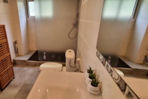 a white bathroom with a toilet and a sink at Beau T2 48m2 tt confort calme 2 adultes 1 enfant in Les Trois-Îlets