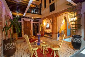 1 dormitorio y sala de estar con mesa y sillas. en Riad Christina, en Marrakech