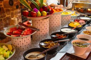 a buffet line with bowls of fruit and other food at Holiday Inn Merida, an IHG Hotel in Mérida