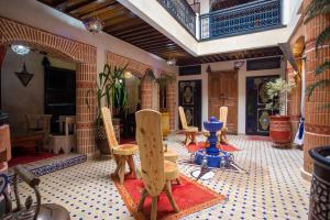 um quarto com cadeiras e uma mesa num quarto em Riad Christina em Marrakech