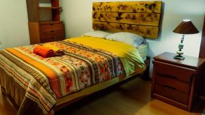 a bedroom with a bed with a wooden head board at Kame House hostel in Huaraz