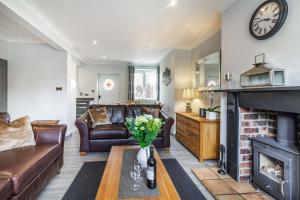 a living room with a couch and a fireplace at Corner Cottage in Bakewell
