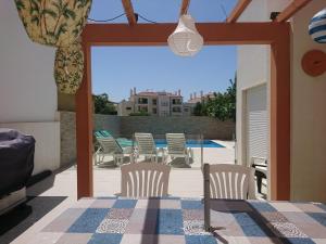 een patio met stoelen, een tafel en een zwembad bij Cabanas de Tavira Conceicao Luxury 4 Bedroom Villa with Private Pool in Cabanas de Tavira