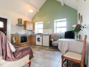 a living room with a table and a kitchen at The Cow Byre in Saltburn-by-the-Sea