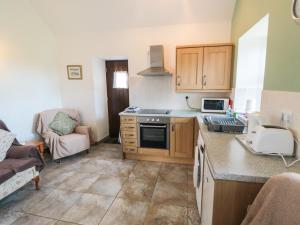 a kitchen with a sink and a stove top oven at The Cow Byre in Saltburn-by-the-Sea
